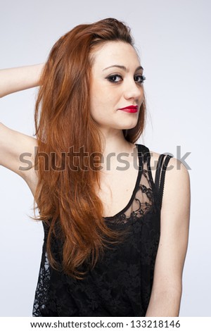 Young pretty woman touching her hair on white background