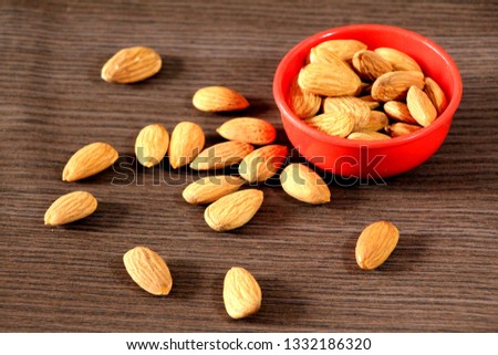 Almonds in the red small bowl Royalty-Free Stock Photo #1332186320