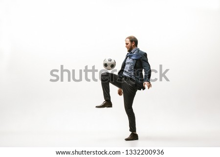 Businessman with football ball in office. Soccer freestyle. Concept of balance and agility in business. Manager perfoming tricks isolated on white studio background.
