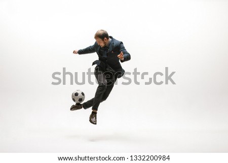 Businessman with football ball in office. Soccer freestyle. Concept of balance and agility in business. Manager perfoming tricks isolated on white studio background. Royalty-Free Stock Photo #1332200984