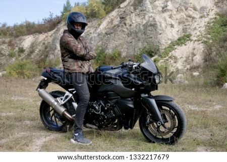 Journey to a motorcycle through a career. The motorcyclist wearing a helmet on a motorcycle