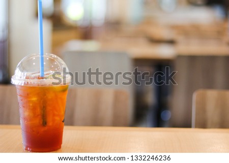 Cold ice lemon tea on wooden table with blur restaurant background - image 