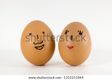 Two eggs with happy and loving face.One egg on wooden spoon with smile face.