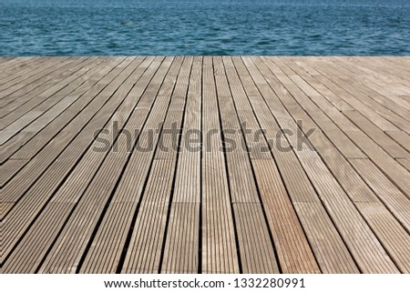 simple background pattern concept surface of wooden deck floor perspective photography with view on swimming pool blue water , copy space
