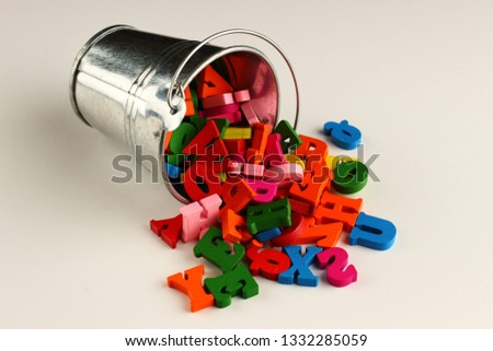 Colored letters in the bucket as a symbol of knowledge and learning