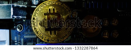 Golden bitcoin cryptocurrency on computer circuit board 