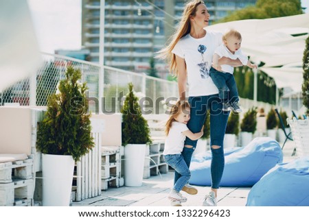 a beautiful young long-haired mom in the park with her beautiful little son and charming daughter