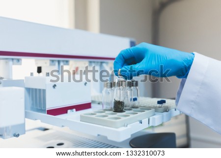 Researcher, doctor, scientist, physicist or laboratory assistant holding test glass tubes and working, experimenting and analyzing in modern lab with equipments, tools and machines. Royalty-Free Stock Photo #1332310073