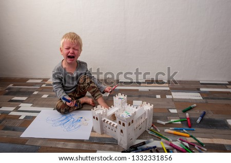 boy was upset and burst into tears while building cardboard castle. Game and intensive learning of preschoolers.