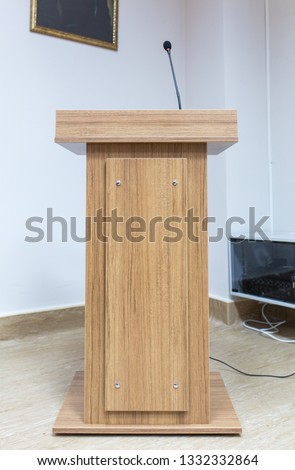 Wooden speech stand and microphone in conference room Royalty-Free Stock Photo #1332332864