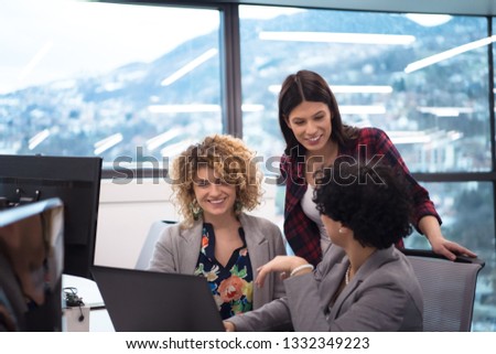 group of young female software developers using laptop computer while writing programming code at modern creative startup office