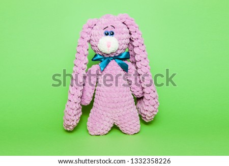 Toy pink bunny or hare on a green background