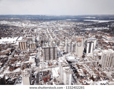 Aerial drone image of downtown Hamilton, Ontario, Canada during winter with apartment buildings and low rise housing covered in snow.