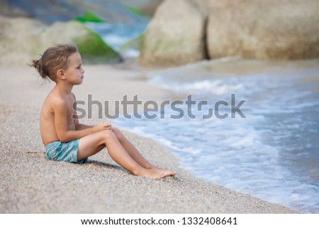 boy sitting on the sand by the sea in Thailand 