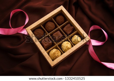 Handmade chocolate truffles box on brown silk background