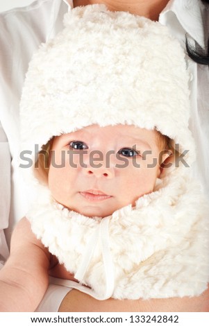 Beauty newborn baby boy with bunny cap in his mother arms