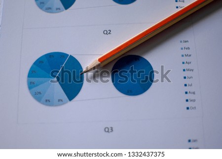 Many charts and graphs with magnifying glass and many pencil. Reflection light and flare. Concept image of data gathering and statistical working.