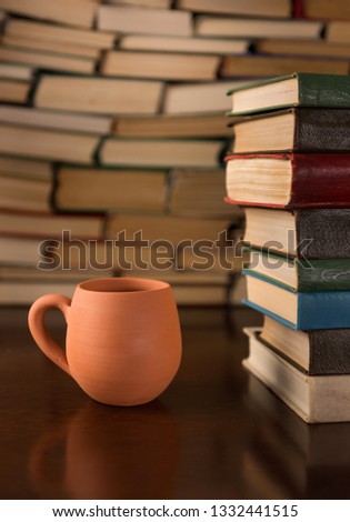 cup and many books on a wooden table