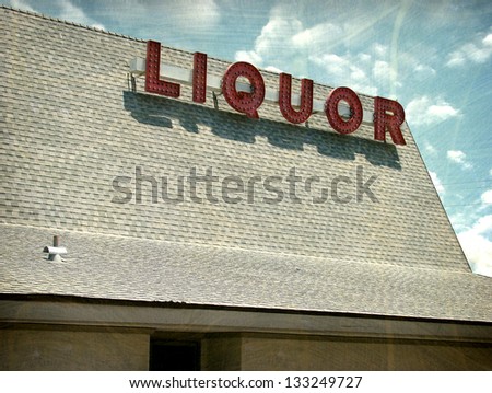    aged and worn vintage photo of liquor sign on roof