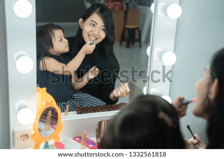 daughter happy face make up with mom at home together