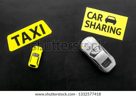 Carsharing vs taxi concept. Comparing carsharing system and taxi. Toy cars and text signs on black background top view space for text