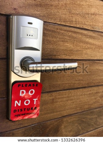 a hotel handle with do not disturb sign and contains Thai letter means Do not disturb