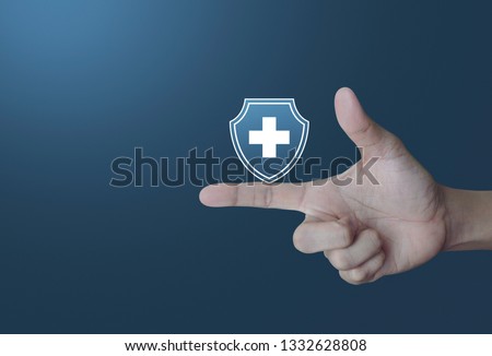 Cross shape with shield flat icon on finger over light gradient blue tone background, Business healthy and medical care insurance concept