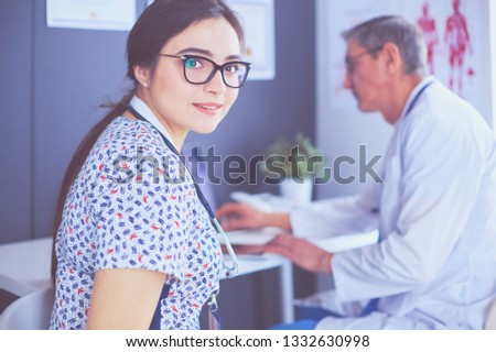 Two doctors speaking in a bright office
