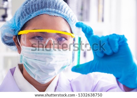 Body past scientist working in laboratory. She is looking in test tube . She is trying and research with blue test tube. Experiment , chemical Photo concept develop and medicine.