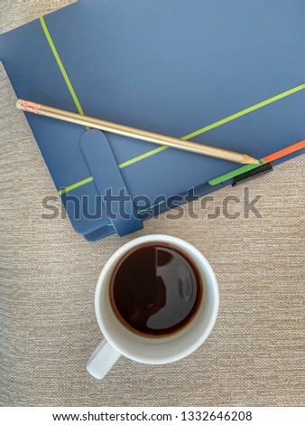 Black coffee, pencil, dark blue note book