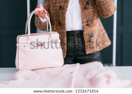 Woman season wardrobe change. Style and elegance. Tweed lady considering trendy pink outfit and bag accessory.