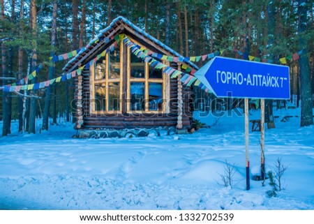 The wooden trade house in the frozen forest in Askat village in Altai Mountains. Russian winter in Siberia. Translation is "Gorno-Altaisk (the name of the town)".