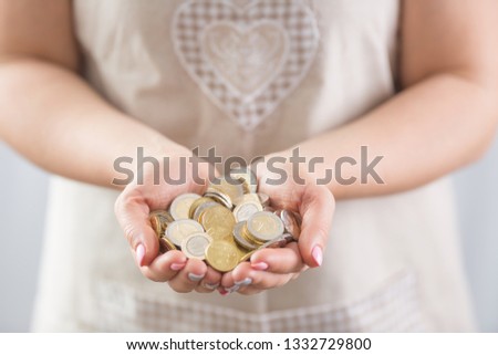 Hands of young hosewife holding euro coins.
