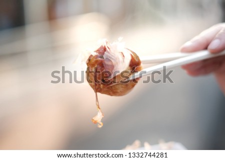 Closeup picture of takoyaki which on chopsticks