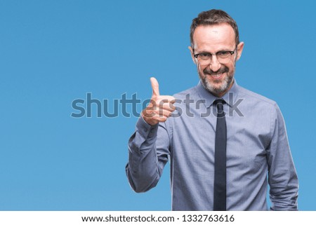 Middle age hoary senior business man wearing glasses over isolated background doing happy thumbs up gesture with hand. Approving expression looking at the camera with showing success.