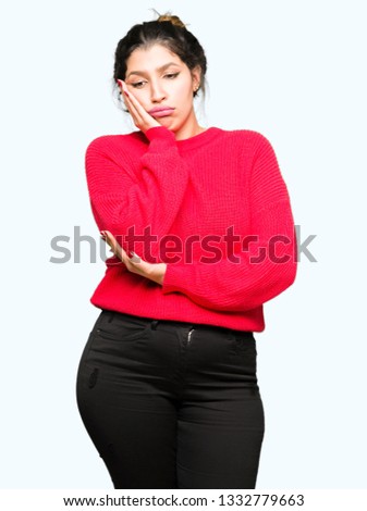 Young beautiful woman wearing red sweater and bun thinking looking tired and bored with depression problems with crossed arms.