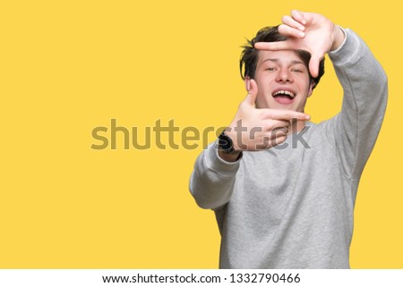 Young handsome sporty man wearing sweatshirt over isolated background smiling making frame with hands and fingers with happy face. Creativity and photography concept.