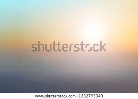 Natural background blurring warm colors and bright sun light. Bokeh or Christmas background Green Energy at sky sunny color orange light patterns plain abstract flare evening clouds blur.