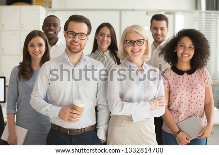 Smiling professional business coaches leaders mentors posing together with diverse office workers interns group, happy multicultural staff corporate employees people looking at camera, team portrait Royalty-Free Stock Photo #1332814700