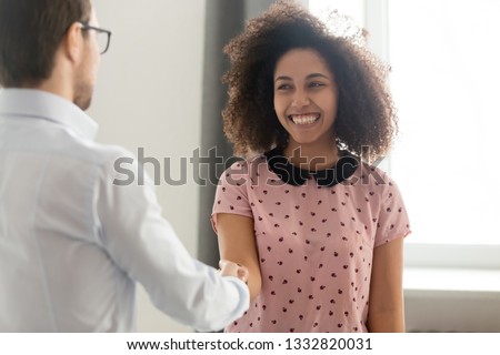Happy african woman student intern worker getting appreciated rewarded hired promoted handshaking boss congratulating black employee with recognition shaking hands expressing gratitude and respect Royalty-Free Stock Photo #1332820031