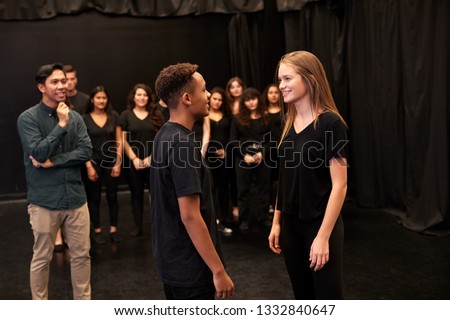 Teacher With Male And Female Drama Students At Performing Arts School In Studio Improvisation Class Royalty-Free Stock Photo #1332840647