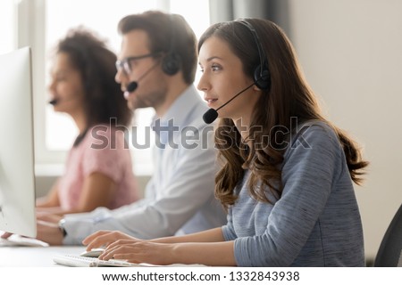 Young woman call center agent operator telemarketer in wireless headset talking consulting online client using computer working in customer service support helpline helpdesk telesales office Royalty-Free Stock Photo #1332843938