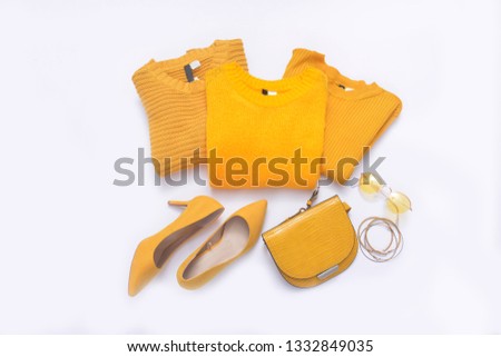 Yellow three yellow three knitted sweater,high hell, sunglasses, handbag on white background
