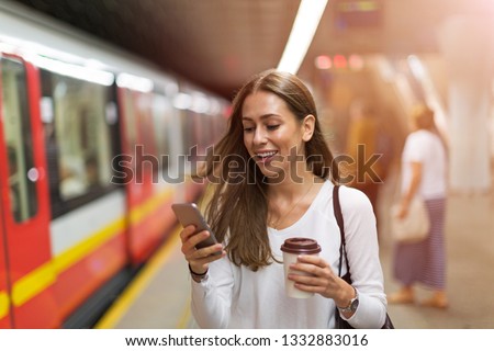 Young woman at subway station  Royalty-Free Stock Photo #1332883016