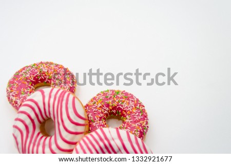 
Picture of donuts  frosted, pink glazed and sprinkles donuts isolated on white background. Glazed donuts on abstract background. Copyspace several objects top view horizontal
