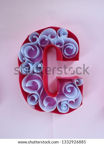 Art decoration of red paper with white paper role inside   C alphabet on pink paper background for decoration