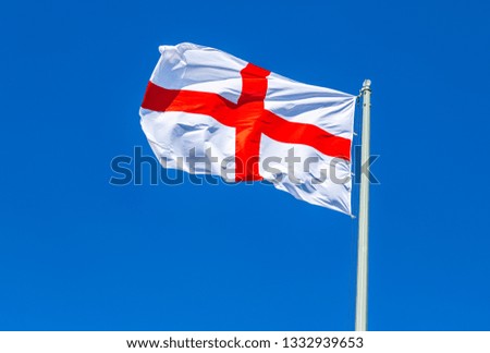 National flag of England waving in the wind against the blue sky