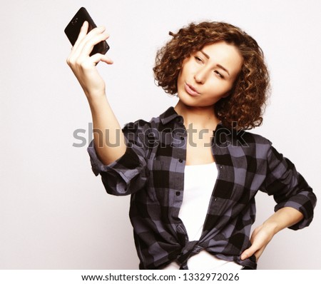 lifestyle, fashion and people concept: beautiful girl taking selfie, studio shoot