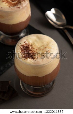 Coffee affogato with vanilla ice cream and espresso. Glass with coffee drink and icecream. Gray background, isolated.