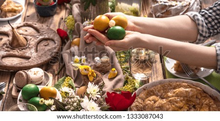 Home Holiday friends or family at the festive Easter table with Easter colored eggs. The concept of the celebration